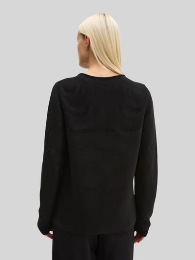 Frauenmodel trägt Regular Fit Pullover aus reiner Baumwolle von MARC O'POLO, unifarben schwarz, Strickoptik, Ganzkörperansicht Rückansicht.