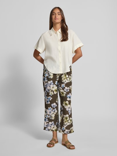 Frauenmodel trägt Hose aus Viskose-Leinen-Mix Modell 'Alexandria' von STEHMANN, braun mit Blumenmuster, verkürzte Passform, Ganzkörperansicht von vorne.