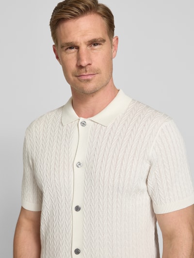 Männermodel trägt Strickshirt mit Polokragen Modell 'Tristao' von JOOP! Collection aus Reine Baumwolle, Slim-Fit, Nahaufnahme Oberkörper.