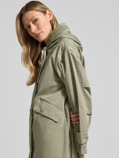 Kobiece model nosi Regular Fit Parka aus reiner Baumwolle od Marc O'Polo, efekt: jednolity kolor, bawełna, krój regular fit, kaptur z tunelem, zamek błyskawiczny dwustronny, listwa z zatrzaskami, tunele, długi rękaw, regulowana nakładka, dół z rybim ogonem, kieszenie z patkami, półzbliżenie boczne.