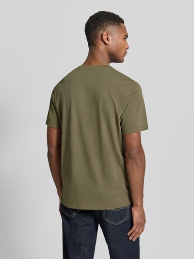 Männermodel trägt Regular Fit T-Shirt aus reiner Baumwolle von camel active in Olivgrün mit Rundhalsausschnitt, Rückenansicht, Ganzkörperansicht.