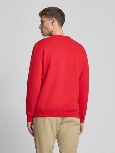 Männermodel trägt Sweatshirt mit Logo und Rundhalsausschnitt von GAP aus rotem Baumwoll-Mix, Regular-Fit, Rückenlänge 69 cm, Ganzkörperansicht Rückansicht.
