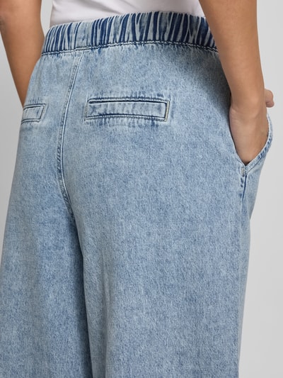 Frauenmodel trägt Wide Leg Jeans aus Baumwoll-Viskose-Mix Modell 'VALERIA' von Vero Moda in heller Denim-Optik, Nahaufnahme Hüftbereich.