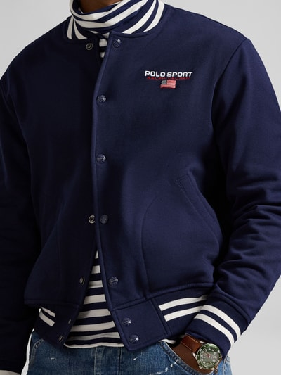 Männermodel draagt Regular Fit Blouson uit katoenmix van Polo Ralph Lauren, unie kleur, collegekraag, drukknoopsluiting, labelschrijfsel, langemouw, geribde boorden, zijzakken, detailopname bovenlichaam