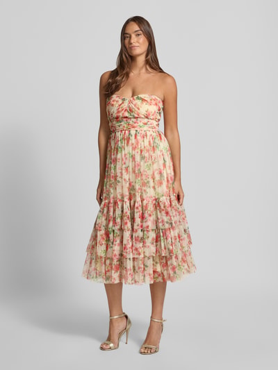 Frauenmodel trägt Midikleid mit floralem Allover-Print von LACE & BEADS in zarten Rosatönen, tailliert, mit Rüschen und Falten, schulterfrei, Ganzkörperansicht von vorne.