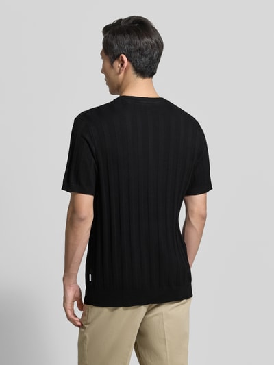 Mannmodel draagt gebreid shirt uit viscosemix met riblook en ronde hals van Lindbergh, regular fit, ruglengte maat M 69 cm, mouwlengte 24 cm, geheel in zwart, structuur zichtbaar, ganzkörperansicht rückansicht.