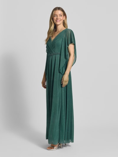 Frauenmodel trägt Maxikleid in Glitzer-Optik mit V-Ausschnitt von Vera Mont, taillierte Passform, Volantärmel, Ziersteinbesatz, Falten-Optik, Farbe Smaragdgrün, Rückenlänge 133 cm, Brustweite 42 cm, Ärmellänge 24 cm, Ganzkörperansicht von vorne.