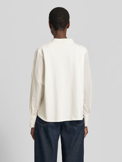 Kobieta modelka nosi Relaxed Fit Bluse mit Schnürung von Marc Cain z bawełny, wzór na całej powierzchni, wiązanie, długość tyłu 59 cm, długość rękawów 60 cm, widok całej sylwetki z tyłu.