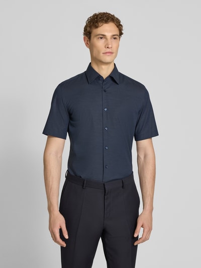Męski model nosi Regular Fit Businesshemd aus Baumwoll-Mix Modell 'KENT SH C1' od BOSS, ciemnoniebieski, popelina, krój regular fit, klasyczny kołnierzyk, przez całą długość guziki, widoczna faktura, przód pokryty wzorem, zdjęcie całej sylwetki z przodu.