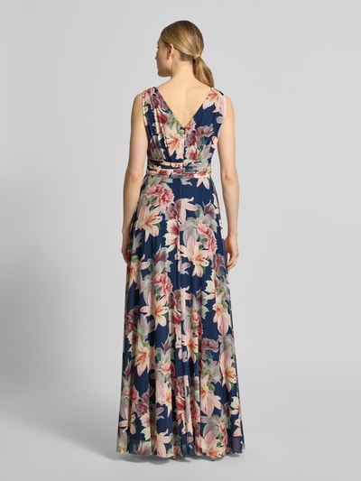 Frauenmodel trägt Maxikleid mit V-Ausschnitt und Gehschlitz von Christian Berg Cocktail, floraler Allover-Look, Material-Mix mit Stretch-Anteil, A-Linie, Rückenlänge 150 cm, Ganzkörperansicht Rückansicht.
