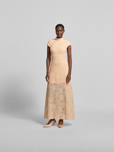 Frauenmodel trägt Maxikleid mit floralen Allover-Details von ROTATE aus elastischem Material-Mix, taillierte Passform, Stehkragen, kurzärmelig, florale Textur, sanfte Beige-Töne, Gesamtlänge 142 cm, Brustweite 38 cm, Ganzkörperansicht von vorne.