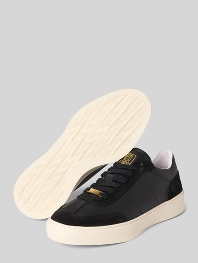 Produktfoto, Sneakersy z naturalnej skóry z detalem z logo model 'Lyonell' od Steve Madden, zaokrąglony czubek, wiązanie, wysokość obcasa w rozmiarze 44: 4 cm, wysokość cholewki w rozmiarze 44: 8 cm, szerokość w rozmiarze 44: 6 cm, czarne z białą podeszwą, gładka tekstura, prostokątne złote detale.