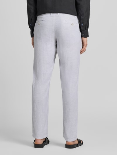 Męski model nosi Hose aus Leinen-Viskose-Mix mit Eingrifftaschen von Christian Berg Men, mieszanka lnu i wiskozy, krój regular fit, zapięcie na guzik i zamek błyskawiczny, wpuszczane kieszenie, szerokość w rozmiarze 50: 47 cm, długość wewnętrzna nogawki w rozmiarze 50: 78 cm, jasnoszare, proste nogawki, tekstura lnu, Ganzkörperansicht Rückansicht.