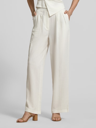 Frauenmodel trägt Hose aus Viskose-Mix mit Strukturmuster von Little Mistress in Creme mit Relaxed Fit, Nahaufnahme Unterkörper.
