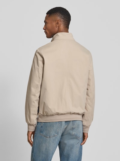 Männermodel trägt Regular Fit Blouson mit Stehkragen von Tom Tailor in Beige, unifarben, Twill-Material, Ganzkörperansicht Rückansicht.