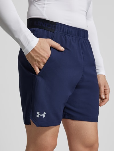Männermodel trägt Straight fit short met logoprint model 'Vanish' van Under Armour, donkerblauw, elastische band, steekzakken, nahaufnahme bovenbeen.