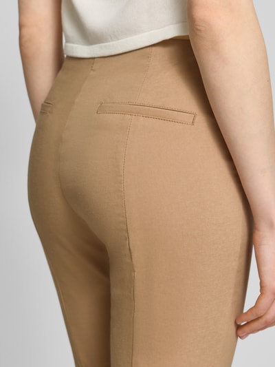 Frauenmodel trägt Slim Fit Stoffhose in verkürzter Passform von Christian Berg Woman, beigefarbener elastischer Baumwoll-Mix, Detailaufnahme Rückenansicht.