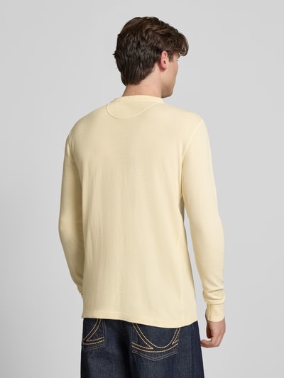 Männermodel trägt Longsleeve mit Knopfleiste von Superdry aus Reine Baumwolle, Regular-Fit, Rundhalsausschnitt, Rückenlänge 72 cm, Ganzkörperansicht Rückansicht.