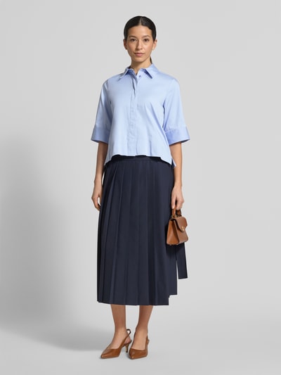 Modelka nosi Boxy Fit Bluse mit verdeckter Knopfleiste von Milano Italy, jasnoniebieski bawełniany miks ze stretchem, kołnierzyk koszulowy, długość pleców 54 cm, długość rękawa 34 cm, widok całej sylwetki z przodu.