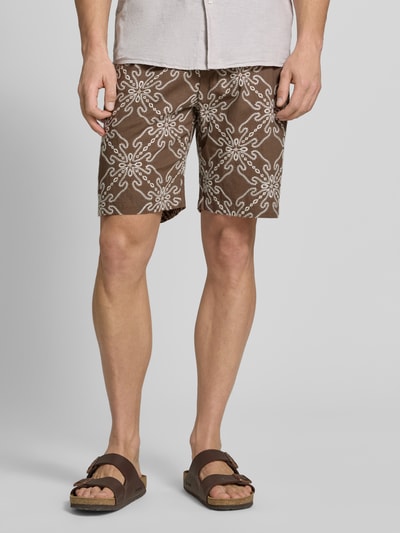 Männermodel trägt Shorts aus Leinen-Mix mit elastischem Bund und Kordelzug von MCNEAL, Relaxed-Fit, Muster braun/weiß, Eingrifftaschen, Ganzkörperansicht von vorne.
