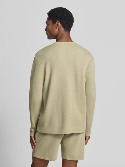 Männermodel trägt Regular Fit Langarmshirt aus Baumwoll-Mix Modell 'WAFFLE LS-SHIRT' von BOSS in Beige, strukturierte Oberfläche, Ganzkörperansicht Rückansicht.