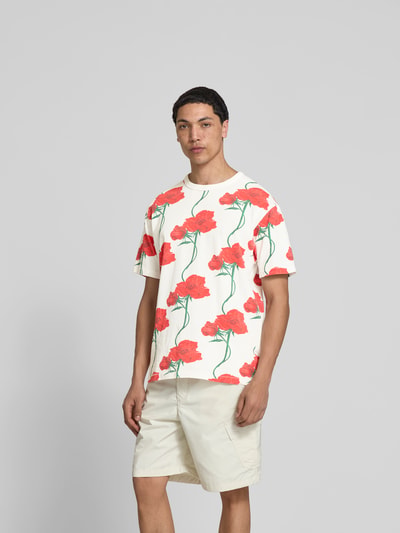 Männermodel trägt T-Shirt mit floralem Allover-Print von Kenzo aus reiner Baumwolle, Regular Fit, helle Farben, Ganzkörperansicht von vorne.