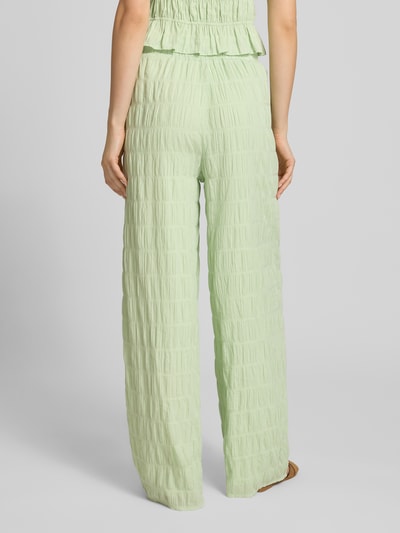 Kobiece model prezentuje spodnie z fakturowanym wzorem i elastycznym pasem Model 'Floris' od OH APRIL z bawełny, krój relaxed fit, mięta, Szerokość w rozmiarze S: 37 cm, Długość wewnętrzna nogawki: 77 cm, zdjęcie całościowe z tyłu