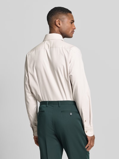 Męski model nosi Regular Fit Business-Hemd mit Kentkragen od OLYMP, bawełniana mieszanka ze stretchem, długi rękaw, detal guziki, kolor beżowy i zielony, krój regular fit, model 'Global Kent', szerokość w rozmiarze 40: 46 cm, długość pleców: 79 cm, długość rękawa: 65 cm, widok całej sylwetki od tyłu
