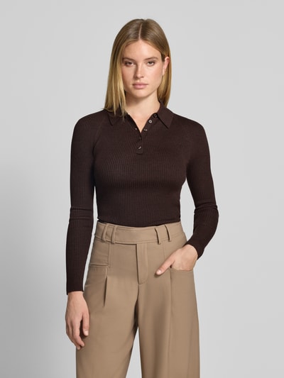 Modelka kobieca ma na sobie sweter wełniany Regular Fit Pullover aus reiner Wolle model 'Faelina' od BOSS w odcieniu ciemnobrązowym, lekko prążkowana tekstura, beżowe spodnie, widok na całą sylwetkę z przodu, damski sweter BOSS.