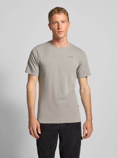 Männermodel draagt Slim Fit T-shirt met ronde hals van G-star, mix van katoen en elastaan, logoprint, ruglengte maat M 72 cm, ganzkörperansicht von voren.