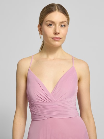 Vrouwenmodel draagt avondjurk met rückseitig überkreuzten spaghettiträgern van Jake*s Cocktail, chiffon, a-lijn, maxi-jurk, v-hals, plooien, vetersluiting aan de achterkant, haakjes- en ritssluiting aan de achterkant, ruglengte maat 36: 126 cm, borstwijdte maat 36: 38 cm, lichtroze kleur, gladde textuur, eenvoudige vormen, nahaufnahme bovenlichaam.