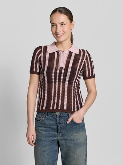 Frauenmodel trägt Modern Fit Poloshirt in Strick-Optik Modell 'PETRA' von Mango, gestreift in Braun und Rosa, Baumwoll-Mix, Polokragen, kurze Knopfleiste, Rückenlänge bei Größe S 53 cm, Ärmellänge 23 cm, Ganzkörperansicht von vorne.