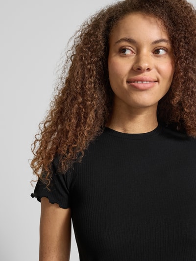 Kobiece model nosi Slim Fit T-Shirt mit Viskose-Anteil Modell 'NICCA' od Pieces, efekt: jednolity kolor, okrągły dekolt, krótki rękaw, wykończenie: falbany, wykończenie materiału: prążek, z dodatkiem wiskozy, zbliżenie na górną część ciała z przodu