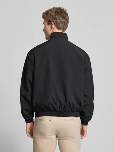 Männermodel draagt Regular fit jack met opstaande kraag Model 'Charge' van JACK & JONES, zwart met ritssluiting en steekzakken, Ganzkörperansicht Rückansicht.