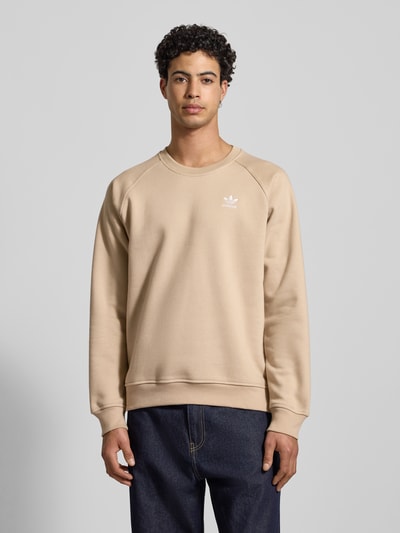 Männermodel trägt Sweatshirt mit Label-Stitching von adidas Originals aus Baumwoll-Mix, Regular-Fit, Beige, Ganzkörperansicht von vorne.