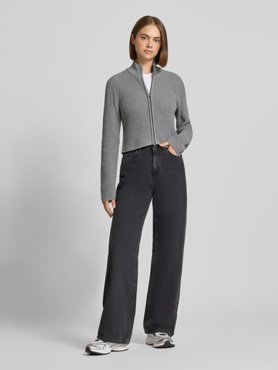 Frauenmodel trägt Slim Fit Jacke aus Baumwoll-Mix Modell 'Dara' von NOISY MAY®, grau, Zweiwege-Reißverschluss, Stehkragen, Ganzkörperansicht von vorne.
