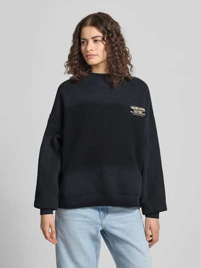 Modelka nosi Regular Fit Sweatshirt mit Logo-Print od ANOTHER COTTON LAB, mieszanka bawełny, stójka, elastyczne wykończenia, widok z przodu na całe ciało.