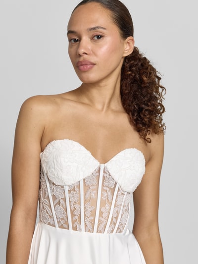 Frauenmodel trägt Brautkleid mit Ziersteinbesatz von Laona in Weiß, florales-Muster, semitransparent, taillierte Passform, Nahaufnahme Oberkörper.