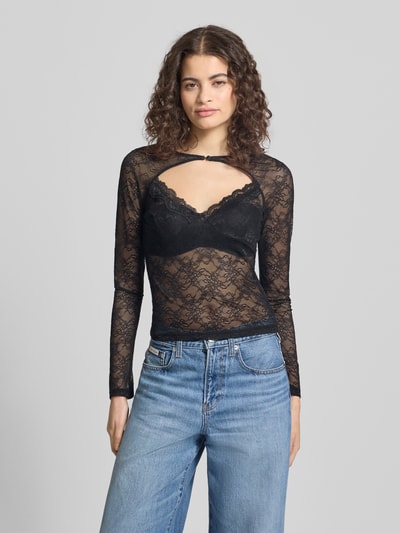 Frauenmodel trägt Longsleeve mit Cut Out von Gina Tricot, schwarzer Spitzenstoff, semitransparent, figurbetont, Material-Mix, Nahaufnahme Oberkörper.
