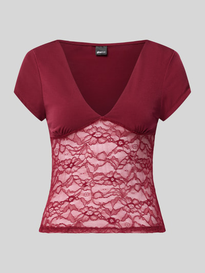 Produktfoto, Damen T-Shirt mit V-Ausschnitt und Spitze von Gina Tricot, Material-Mix mit Stretch-Anteil, Slim-Fit, Rückenlänge 51 cm in Größe S, bordeauxrot mit transparenter floraler Spitze und glatter Oberfläche.