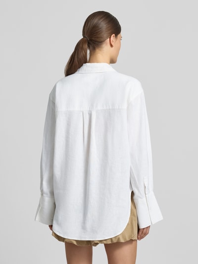 Modelka nosi Regular Fit Bluse aus Leinen-Baumwoll-Mix od Gina Tricot, mieszanka lnu i bawełny, krój regular fit, kołnierzyk koszulowy, listwa guzikowa, długość tyłu w rozmiarze S: 74 cm, długość rękawów w rozmiarze S: 60 cm, widok całej sylwetki z tyłu.