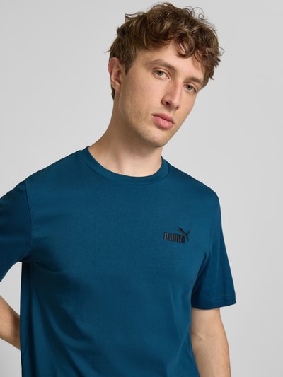 Männermodel trägt Regular Fit T-Shirt mit Logo-Stitching von PUMA PERFORMANCE aus Reine Baumwolle, Rundhalsausschnitt, Nahaufnahme Oberkörper.