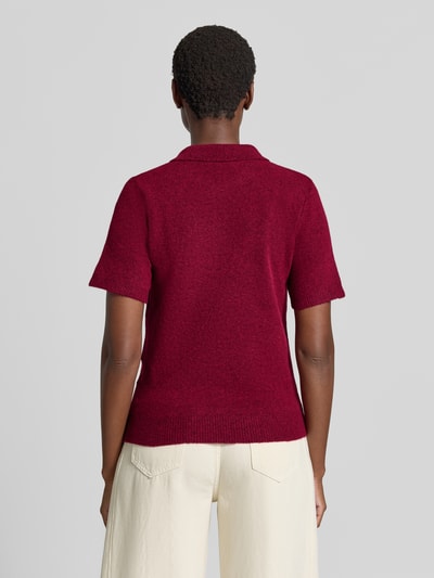 Frauenmodel trägt Slim Fit Poloshirt mit Woll-Anteil Modell 'Dasila' von ICHI in Dunkelrot, Strick-Optik, Rückenansicht, Ganzkörperansicht Rückansicht. Elastischer Material-Mix, kurzärmeliges Design, Polokragen, Rückenlänge 57 cm, Ärmellänge 22 cm bei Größe S.