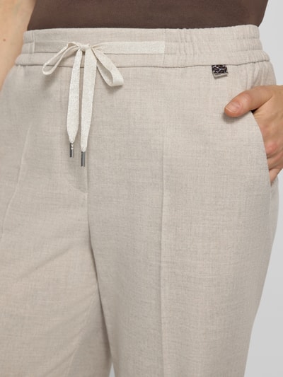 Vrouwenmodel draagt Straight Fit stoffen broek met viscose van Marc Cain, elastische materiaalmix, persplooien, elastische band, tunnelkoord, context: Dames stoffen broek, bandwijdte maat 36: 37 cm, binnenbeenlengte maat 36: 78 cm, detailopname heup/bovenbeen.