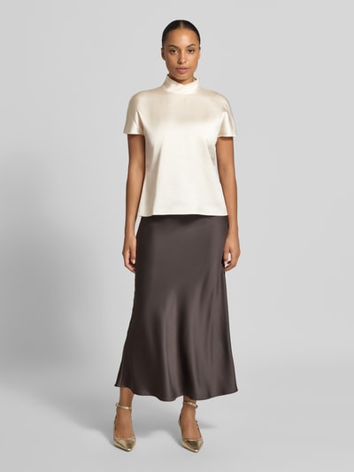 Frauenmodel trägt T-Shirt aus Viskose-Mix mit Stehkragen von Stefanel in Creme, Satin-Optik, lockere Passform, Ganzkörperansicht von vorne.
