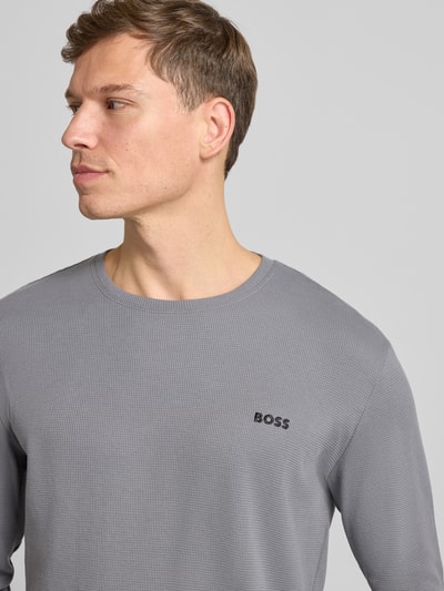 Männermodel trägt Regular Fit Langarmshirt aus Baumwoll-Mix von BOSS, Optik: Unifarben, Muster: Waffelstruktur, Label-Stitching, Rundhals, Nahaufnahme Oberkörper.
