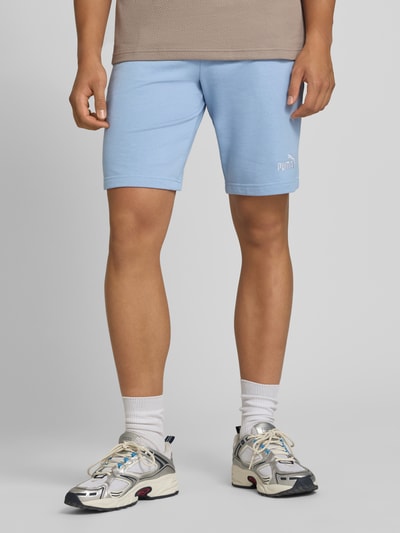 Männermodel trägt Shorts mit Logo und elastischem Bund von PUMA in Hellblau, Baumwoll-Mix, Regular Fit, Ganzkörperansicht von vorne.