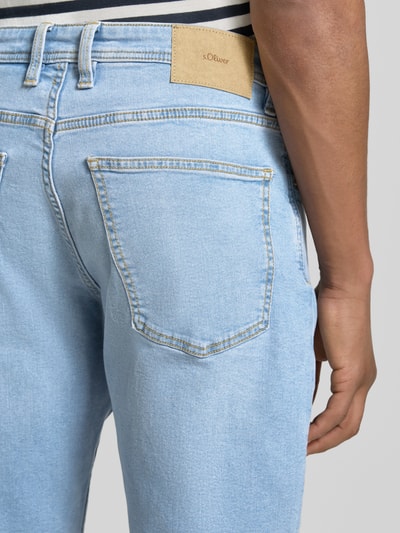 Männermodel trägt Regular Fit Jeans-Bermudas aus Baumwoll-Mix von s.Oliver RED LABEL in Denim-Optik mit Label-Patch, Kontrast-Nähte, 5-Pocket-Design, Nahaufnahme Rückansicht.
