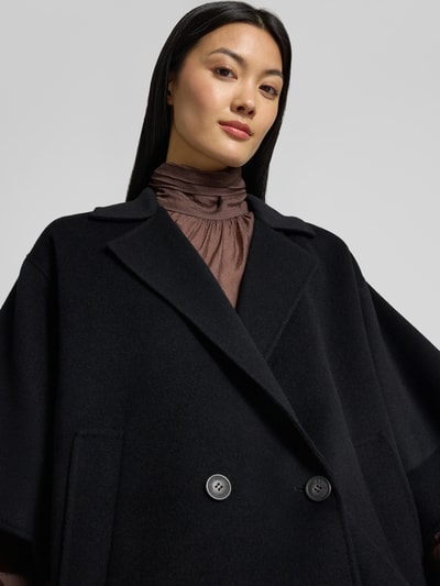 Frauenmodel trägt Regular Fit Kurzmantel aus reiner Schurwolle Modell 'NEO' von Weekend Max Mara in Schwarz, Nahaufnahme Oberkörper.