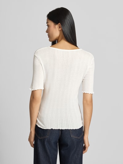 Frauenmodel trägt T-Shirt mit Wellensaum und Rundhalsausschnitt Modell 'UNICA' von b.young, Ripp-Optik, reine Baumwolle, Slim Fit, Rückenlänge 50 cm, Cremefarbe, Ganzkörperansicht Rückansicht.